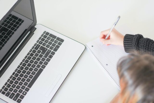 person on laptop taking notes