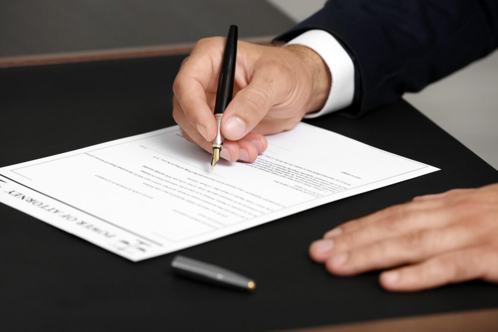 man signing document