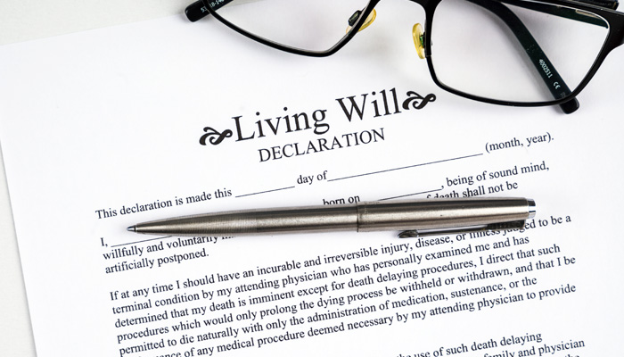 living will declaration form with glasses and silver pen