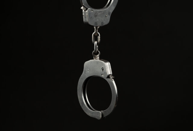 Locked police handcuffs on a black background