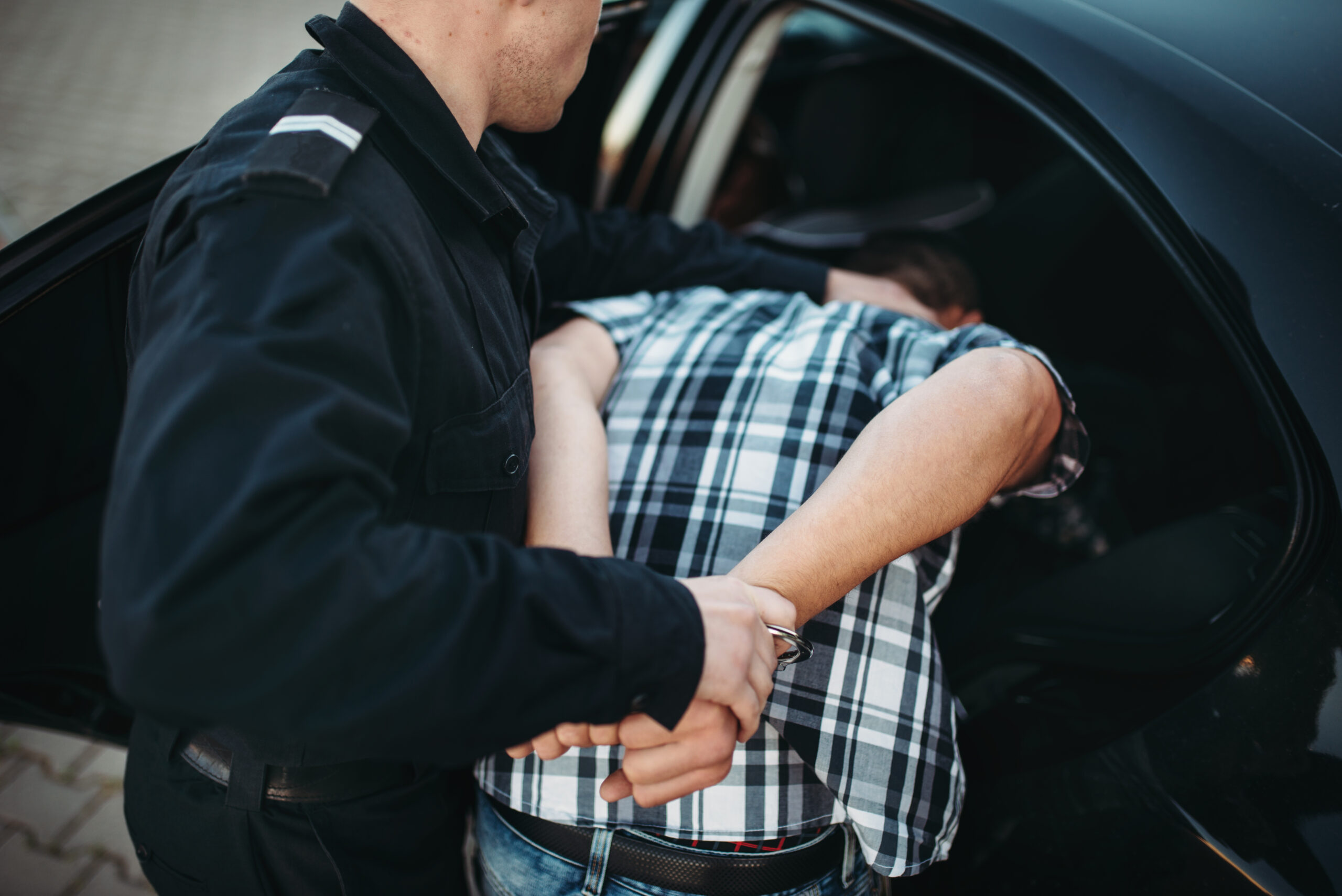 Police officer put the intruder into the car. Cop at the work. Law protection concept, professional safety control