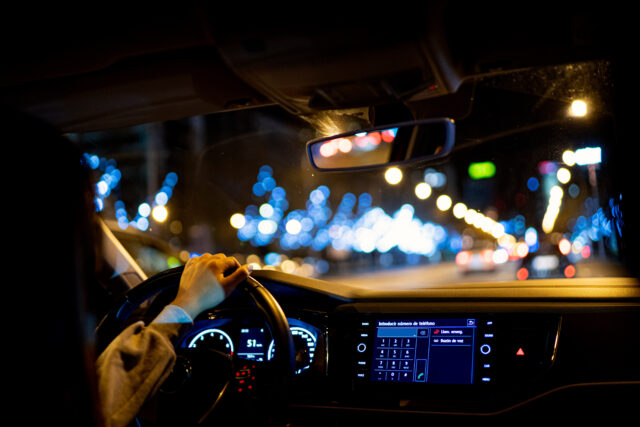A woman driving a car at night