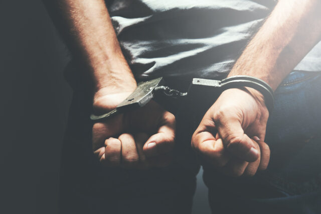 man hand handcuffs in back